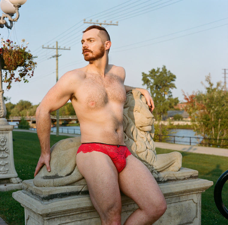 Photo: Les Huard, Model Tristan Ginger - Red lace panties posing with lion statue